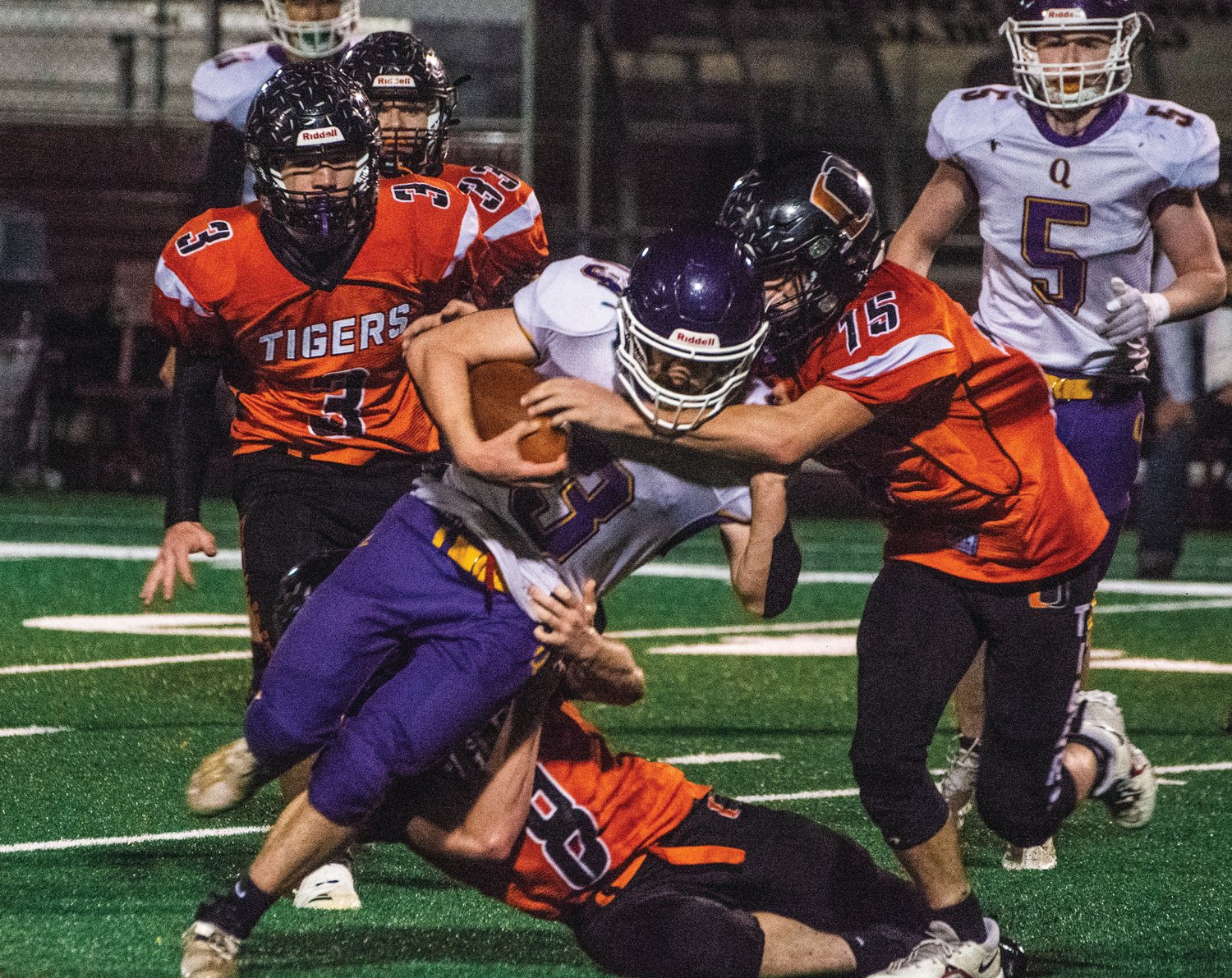 At left, it takes a village — to tackle the Rangers’ Bishop Budnek, as the Odessa Tigers learn during Saturday’s game in Moses Lake.